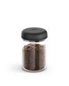 Fellow Atmos Vacuum Canister with black lid, filled with coffee beans on a white background.